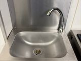 a stainless steel sink with a faucet in the corner