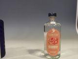 a bottle of alcohol sitting on a counter next to a bottle of liquor