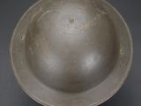 an old metal bowl sitting on top of a black table