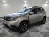 La Dacia argentée est garée dans une pièce au sol carrelé en damier.