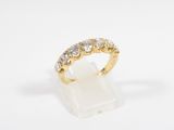 a gold and diamond ring on a white marble block