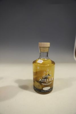une bouteille d'alcool posée sur une table à côté d'un verre de vin