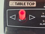 a table top with a red button on it