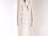 the white coat is hanging on a hanger on the wall