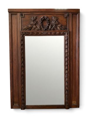 a large mirror with a wooden frame and a decorative design