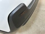 a close up of a car ' s bumper with a small hole in it