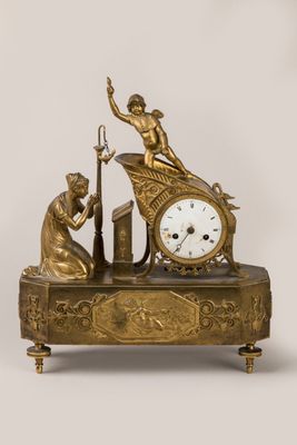 a gold clock with a statue of a man and a woman on it