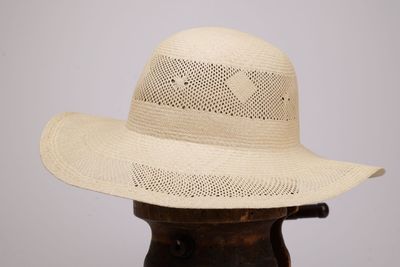 chapeau de paille beige sur une tête de mannequin, sur fond blanc