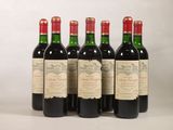 quatre bouteilles de vin sont alignées sur une surface blanche