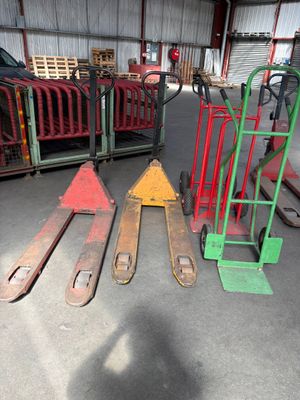 trois palettes et un diable dans un entrepôt