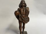figurine antique en bronze représentant un garçon tenant un panier de fruits