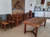 tables and chairs in a room with a stone wall in the background