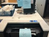 une photo d'une cuisine avec un micro-ondes et un plan de travail sur lequel sont posés de nombreux objets