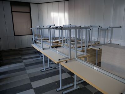 rows of empty desks in a room with a checkered floor