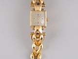 an image of a woman ' s wrist watch with a chain around it
