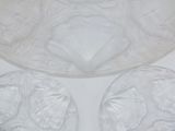 three clear glass dishes with shells on them sitting on a white surface