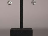a close up of a pair of earrings on a stand