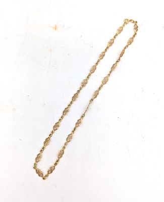 gros plan d'un collier en or sur une surface blanche
