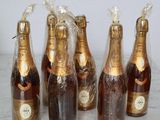 six bottles of champagne are lined up on a marble table