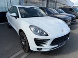 white porsche macan parked in front of a building in a parking lot