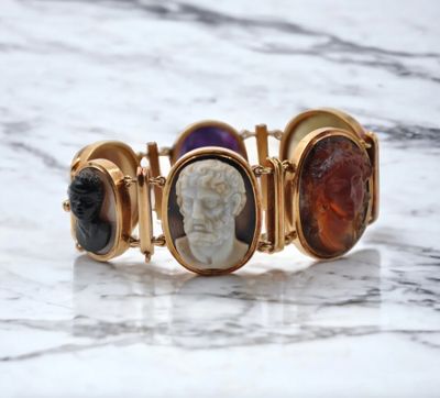 a close up of a bracelet with three different colored stones on it