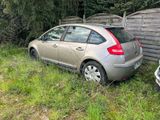 une voiture garée dans l'herbe, près d'une clôture
