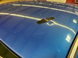 a close up of a blue car with a sticker on it