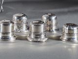 six salières et poivrières en argent posées sur une table