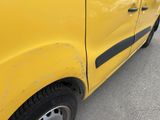 a close up of a yellow car with a black stripe on it