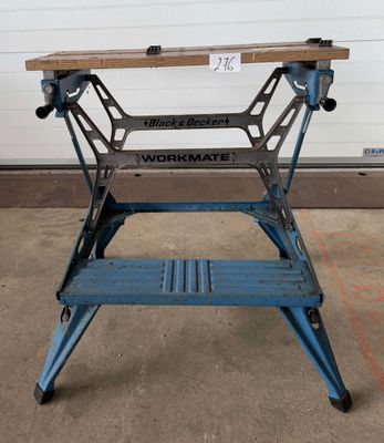 Une table de travail bleue est posée devant une porte de garage