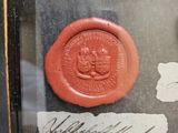 a wax seal with a seal on it in a glass case