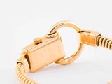 gold plated bracelet with a clasp on a white background