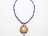 un collier composé de perles bleues et d'un pendentif rose