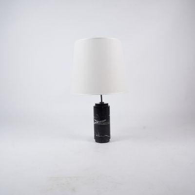a black marble lamp with a white shade on a white background
