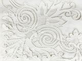 embroidered white fabric with a floral design on top of it