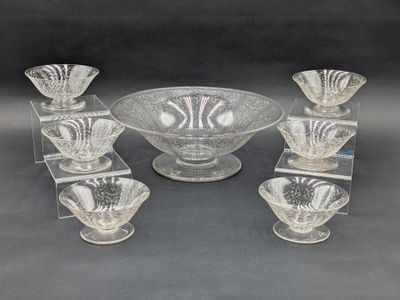 six bols en verre transparent et un bol posé sur un socle