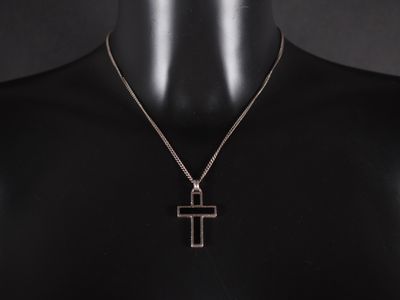 un collier avec une croix en argent sur un mannequin, un mannequin, un mannequin, un mannequin, un mannequin, un mannequin, un mannequin, un mannequin, un manne