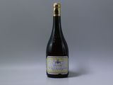 une bouteille de vin posée sur une table blanche