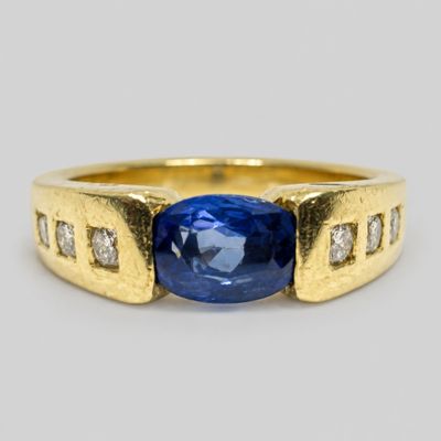 a close up of a blue sapphire and diamond ring