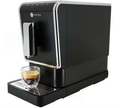 a black coffee machine sitting on top of a counter next to a cup of coffee