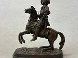 bronze statue of a man on a horse with a helmet on