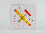 un petit avion miniature dans une boîte transparente rehaussée de touches de rouge et de jaune