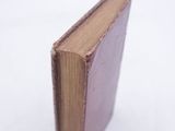 a small brown book sitting on a white surface