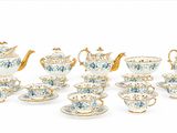 de nombreuses tasses, soucoupes et théières sur la table