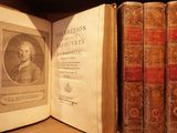 an old book with a picture of a man sitting in front of a row of books