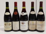 six bottles of red wine are lined up on a table