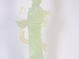 statue d'une femme tenant une bougie sur un socle, sur fond blanc