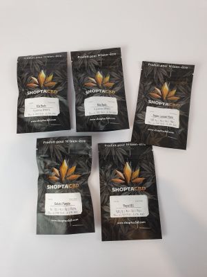 four bags of cannabis tea sit on a white surface