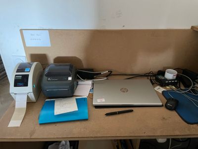 un bureau sur lequel se trouvent un ordinateur portable, une imprimante et d'autres objets