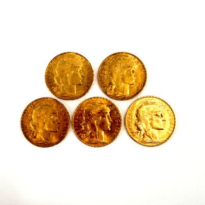 four different types of gold coins sitting on top of a white surface